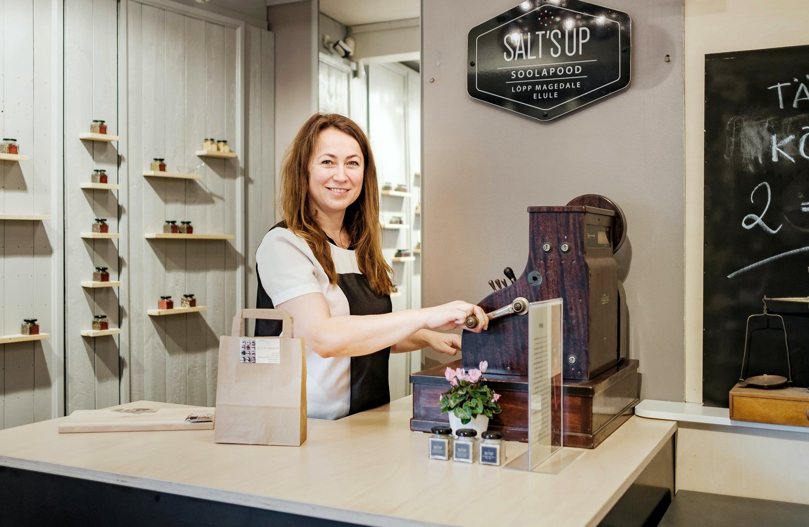 A shopkeeper at the counter of a small independent shop.