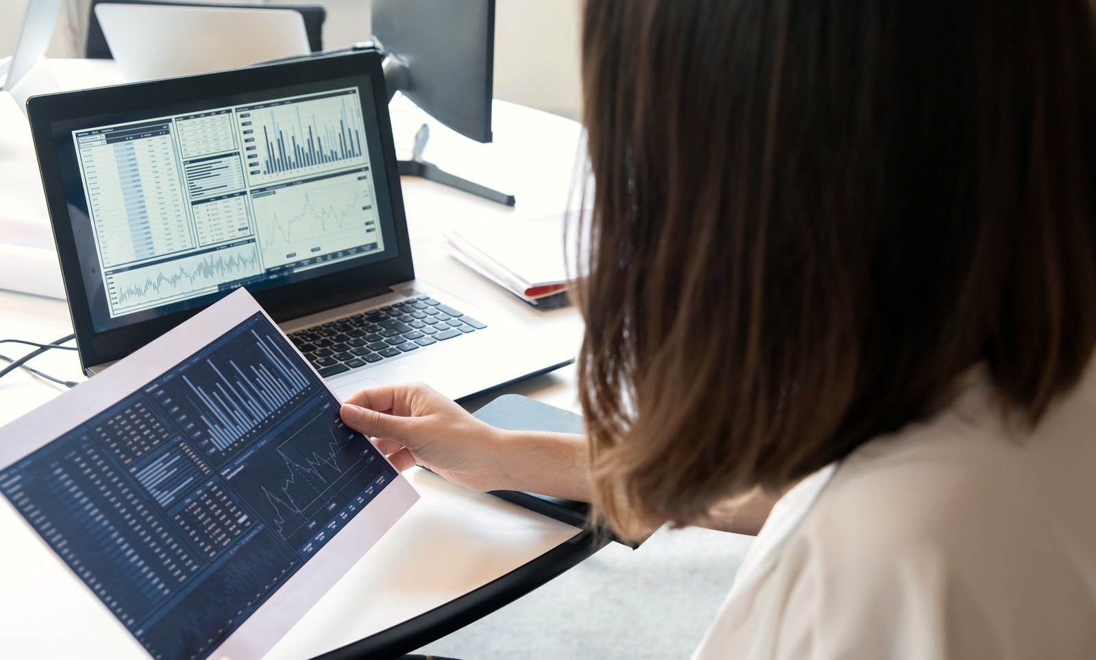 Reviewing a performance dashboard alongside a printed report.